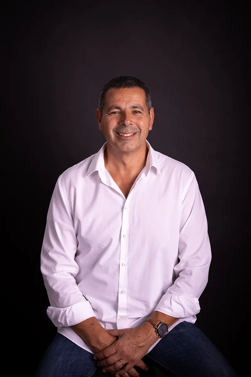 Luís Oliveira, fundador da Pastelaria Patyanne, sentado e a sorrir em estúdio fotográfico